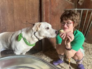 girl holding baby chick and dog sniffing the bird